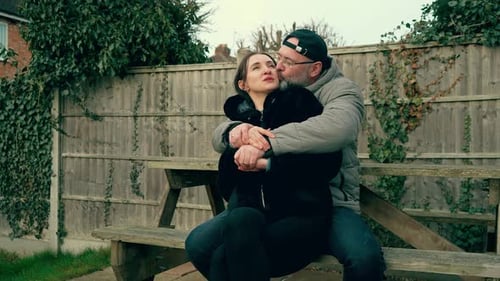 Loving Couple Embracing on a Bench Outdoors