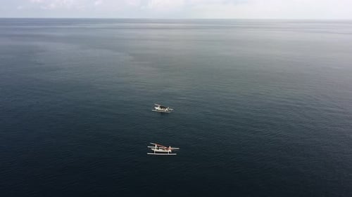 two fisherman boat isolated in middle of blue ocean in a tropical paradise during a sunny day , aeri