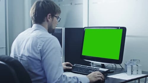 Engineer is Working on Computer. Display with Green Screen.