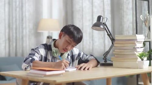 Asian Teenager Studying At Home, Asia Teen Writing While Sitting On The Table