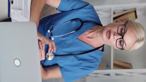 Medical Professional at Desk Using Laptop Computer