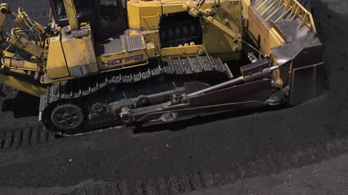 Luftaufnahme von Bulldozern, die Kohle im Wärmekraftwerk transportieren