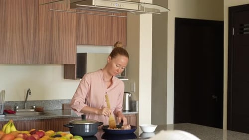 Woman Cooking Food in Modern Kitchen at Home