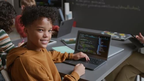 Portrait of Happy Polyethnic Schoolboy Working on Computer Code at Lesson