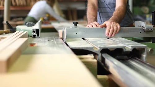 Man Working with a Saw in Workshop