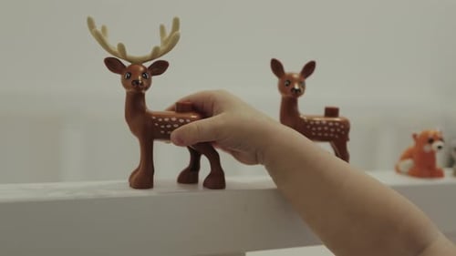 Ein Kind spielt glücklich mit bunten Spielzeugtieren in einem hellen, fröhlichen und sonnigen Raum
