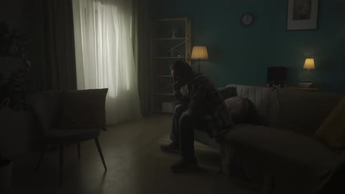 A Devastated Young Man Sits in a Room in the Dark and Alone Change of Day and Night Transience of