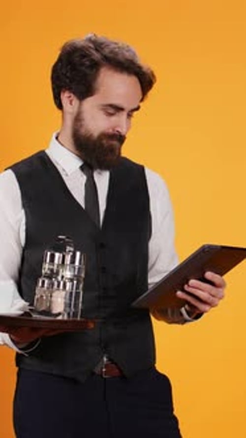 Vertical Video Staff Member Calculates Check on Tablet