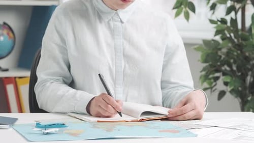 Travel Agent Plans a Trip By Studying a World Map