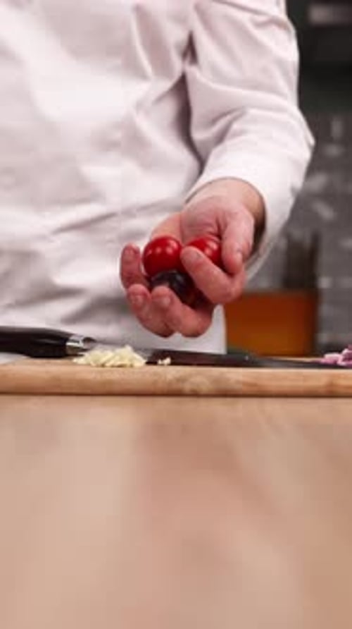 Der Chefkoch bereitet in der Küche ein köstliches Gericht mit Tomaten zu. Nahaufnahme