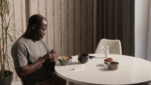 Black Man with Asthma Eating Breakfast and Taking Pills in Kitchen at Home