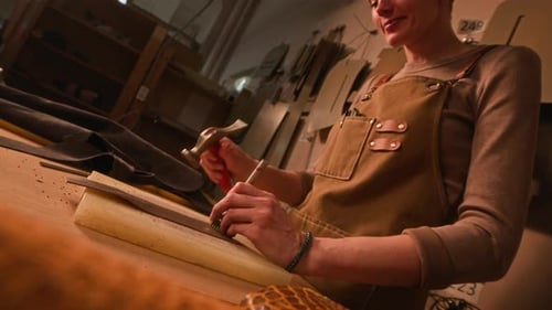 Woman Punching Holes in Leather in Workshop