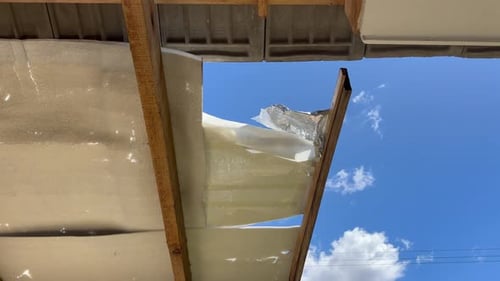 Damaged roof insulation under exposed wooden roof structure