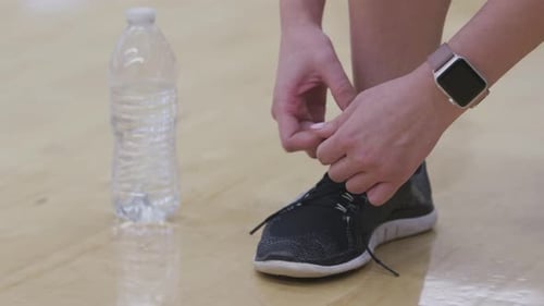 Close up of athlete tying shoelace at gym getting ready for fitness workout