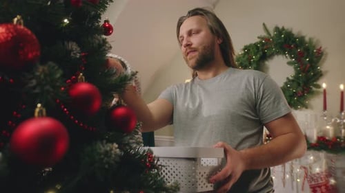Father and Daughter Decorate Christmas Tree Together at Home