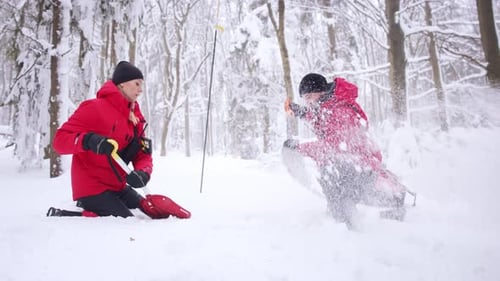 Mountain rescue team on winter operation searching for avalanche victims in forest
