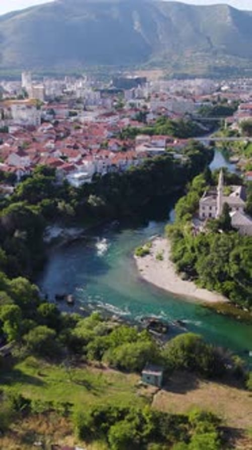 Vue par drone de Mostar et de la rivière Neretva avec la mosquée et les toits dans une vallée verdoyante