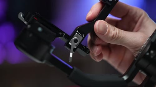 Closeup Side View of Unrecognizable Operator Male Configures Steadicam for Shoot Regulating Camera