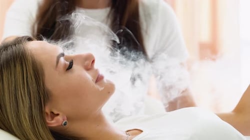 Woman Exhaling Smoke From Electronic Cigarette