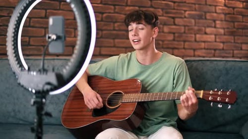 Young Man Plays Guitar, Sings on Camera
