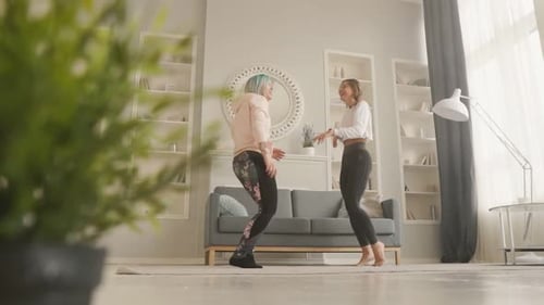 Two Happy Young Woman Dancing at Home Having Fun and Celebrating