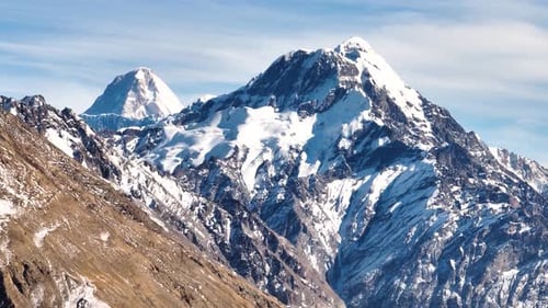 Majestic glacier and snow capped high mountain peaks under a blue sky