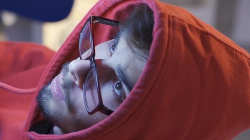 Young Adult Wearing Glasses And Red Hoodie