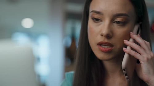 Elegant businesswoman seriously talking on phone with partner at modern office