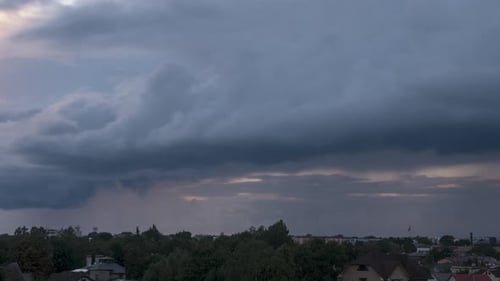 Time lapse of fast moving dramatic dark thunderstorm clouds moving over the city skyline, overcast s