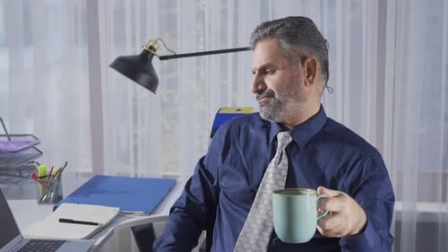 Thoughtful mature businessman working alone in the office.
