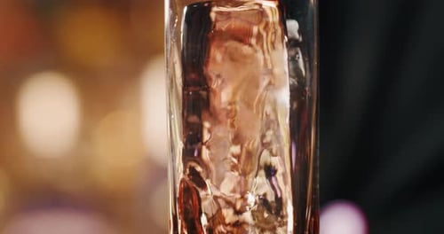 Close up of a professional bartender is preparing an long drink cocktail to customers at the bar o