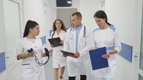 Medical Team Walking Through Hospital Hallway