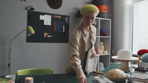 Milliner Working with Fabrics and Hats in Studio