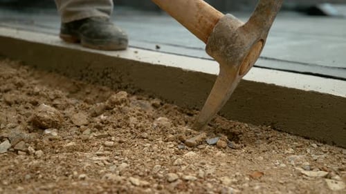 Nahaufnahme eines Arbeiters mit einer scharfen Spitzhacke