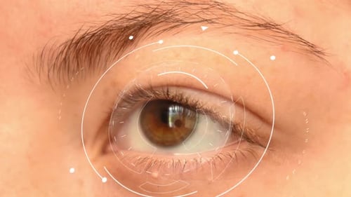 Close up of a young redhead female's light brown eye, with white futuristic high technology elements