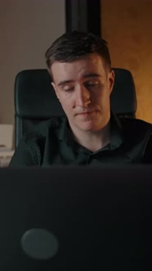 Man Talking in Front of Computer at Night