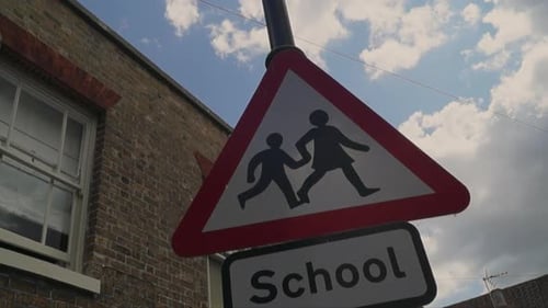 School children crossing street warning sign.