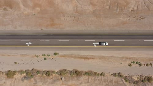 Cars driving on a Desert road surrounded by dry land, Aerial view