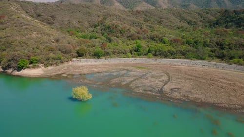 Aerial drone flying over a blue water lake with mountains landscape