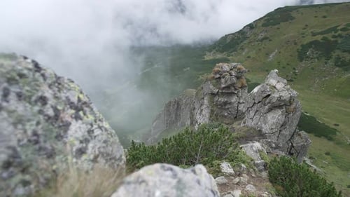 Felsen in den Bergen bei bewölktem Wetter auf grünem Hintergrund