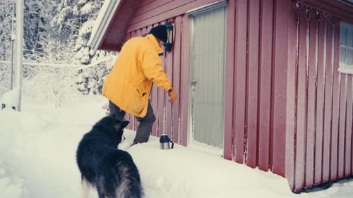 Caucasian Man With Alaskan Malamute Dog Pet Entering A Cabin During Winter. Close Up