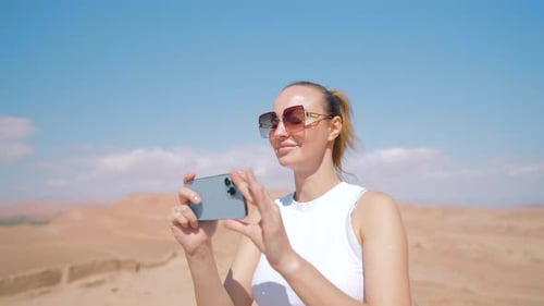Tourist Taking Pictures in Desert Landscape with Smartphone