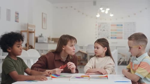 Teacher Helping Children with Modeling Clay in Classroom