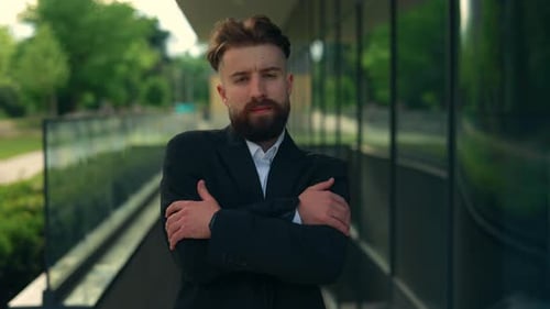 Portrait of the Businessman in Formal Suite Standing Crossing His Hands