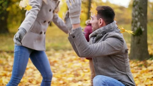 Family Fun Throwing Autumn Leaves in the Park