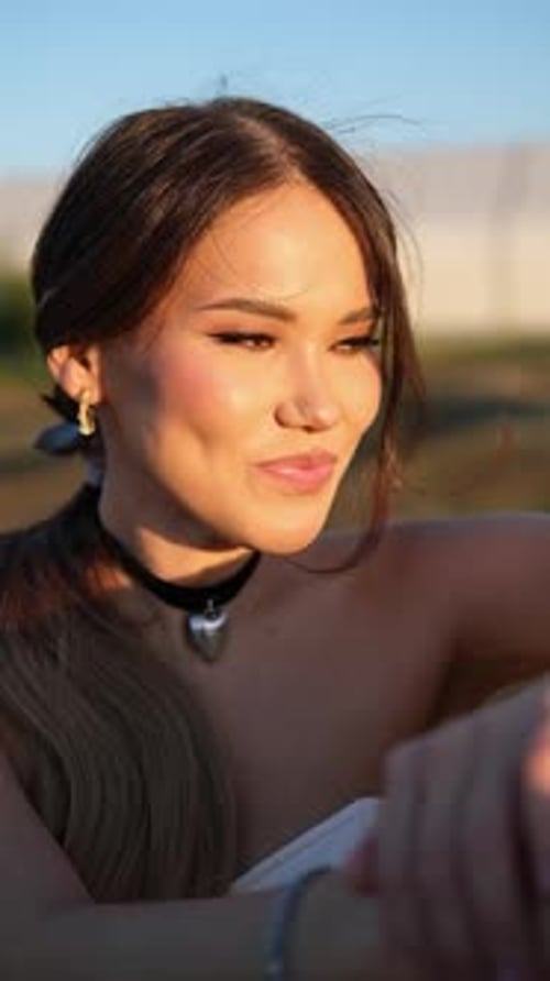 Belle jeune femme asiatique sourit à l'extérieur, elle a un maquillage parfait, la lumière du décor doux