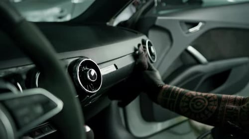 Salon of a prestigious modern interior detailing luxury car Side view of man taking care
