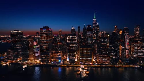 Skyline of luminous New York at night. Waterfront of the majestic city at the East River.