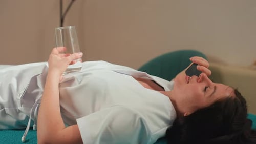 Serene Female Patient Receiving Microcurrent Facial Therapy in Clinic Woman Dressed in White Robe