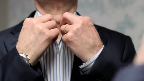Man Fastens Shirt Collar Ready for Business